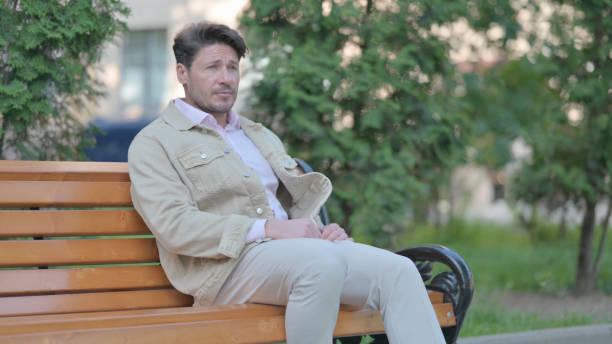istock Middle Aged Man Coming and Sitting on Bench Outdoor 1775126035
