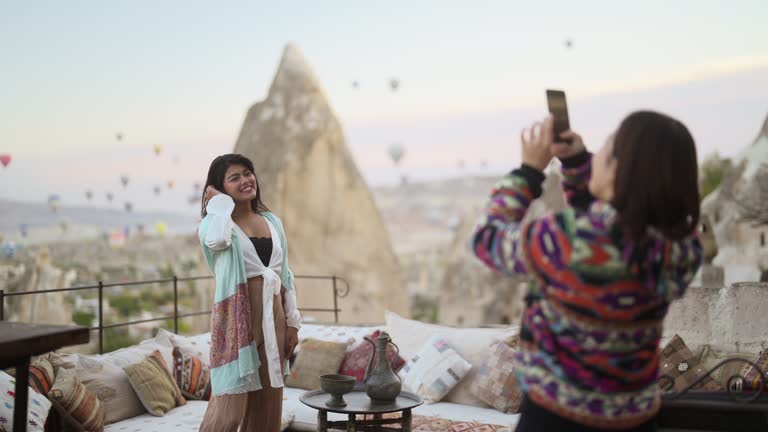 Two multi-racial female friends taking photos in Cappadocia