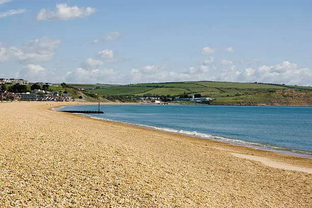 "View looking north along the shingle Preston Beach at the seaside resort of Weymouth, Dorset."
