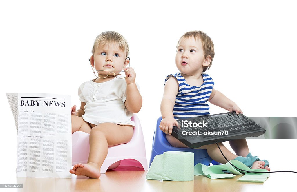 funny children girl and boy sitting on chamberpot with newspaper funny children girl and boy sitting on chamberpot with newspaper and keyboard Baby - Human Age Stock Photo