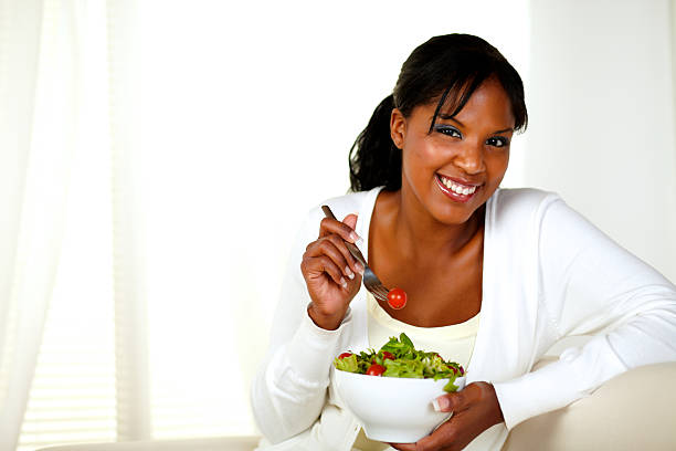 istock Young woman smiling and eating a vegetable salad 177513875