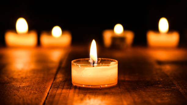 istock Candles Glowing in the Dark on a Wooden Table 1775141311