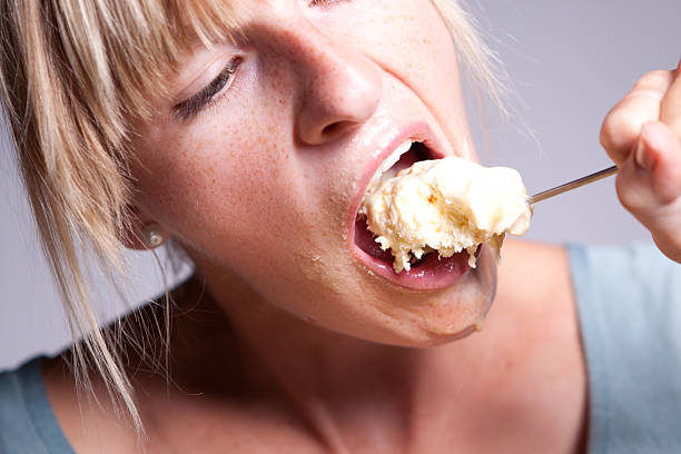 Cold obsession Girl feeding herslef with ice cream. guzzling stock pictures, royalty-free photos & images