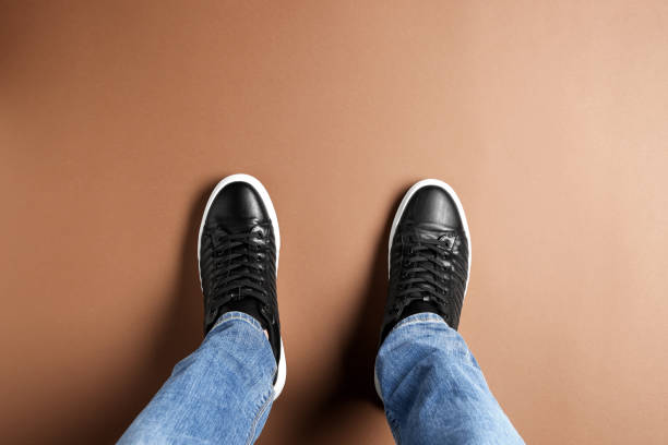 istock Man in black leather shoes standing on light brown background, top view 1775143511