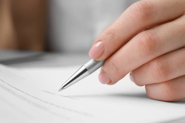 istock Closeup view of woman signing document at table 1775143544
