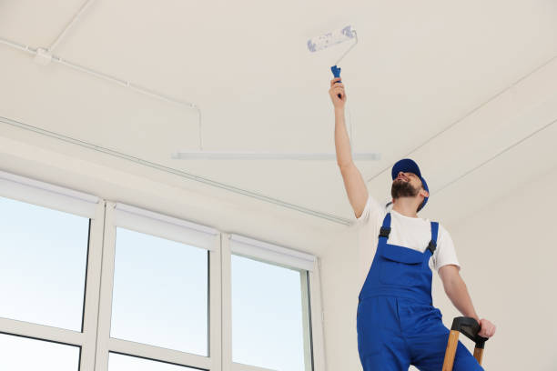 istock Worker in uniform painting ceiling with roller indoors, low angle view 1775145811