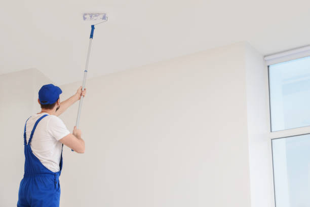 istock Worker in uniform painting ceiling with roller indoors, low angle view. Space for text 1775145818