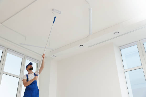 istock Worker in uniform painting ceiling with roller indoors. Space for text 1775145894