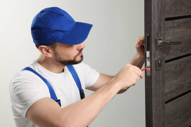 istock Worker in uniform with screwdriver repairing door lock indoors 1775147382