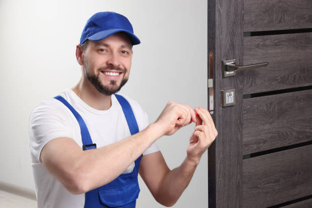 istock Worker in uniform with screwdriver repairing door lock indoors 1775147900