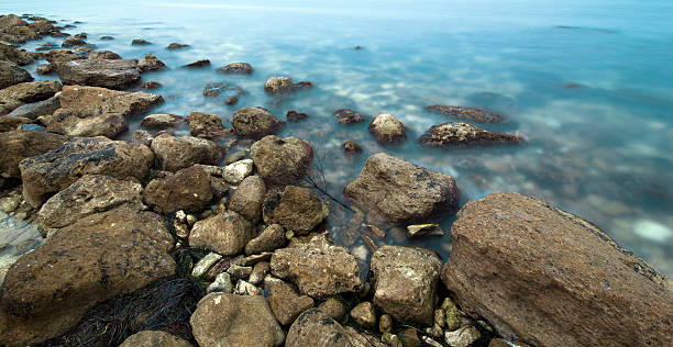 The sea coast with brown stones stock photo