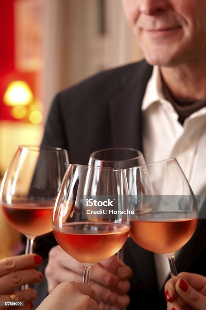 Celebrating With Wine Four glasses of wine being clinked together as a toast at a celebration or function Adult Stock Photo
