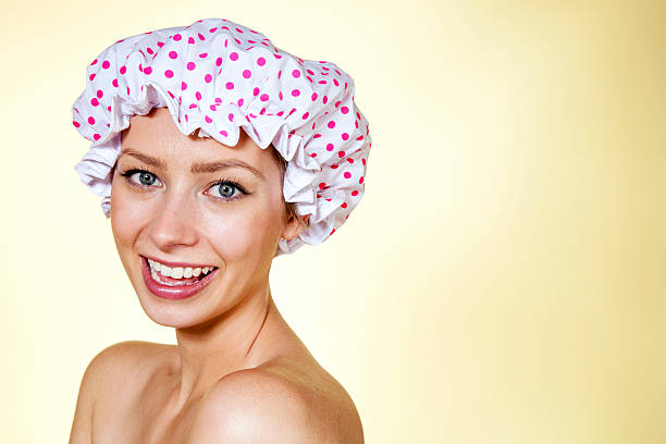 Attractive smiling young woman wearing a retro shower cap stock photo