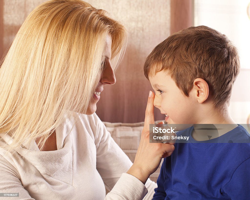 Mother and son Happy mother and her son playing together at home. Adult Stock Photo