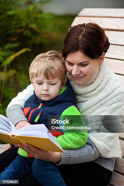 Młode Matki I Maluch Syn Czytanie Książki Na Ławce Na Zewnątrz - zdjęcia stockowe i więcej obrazów Chłopcy