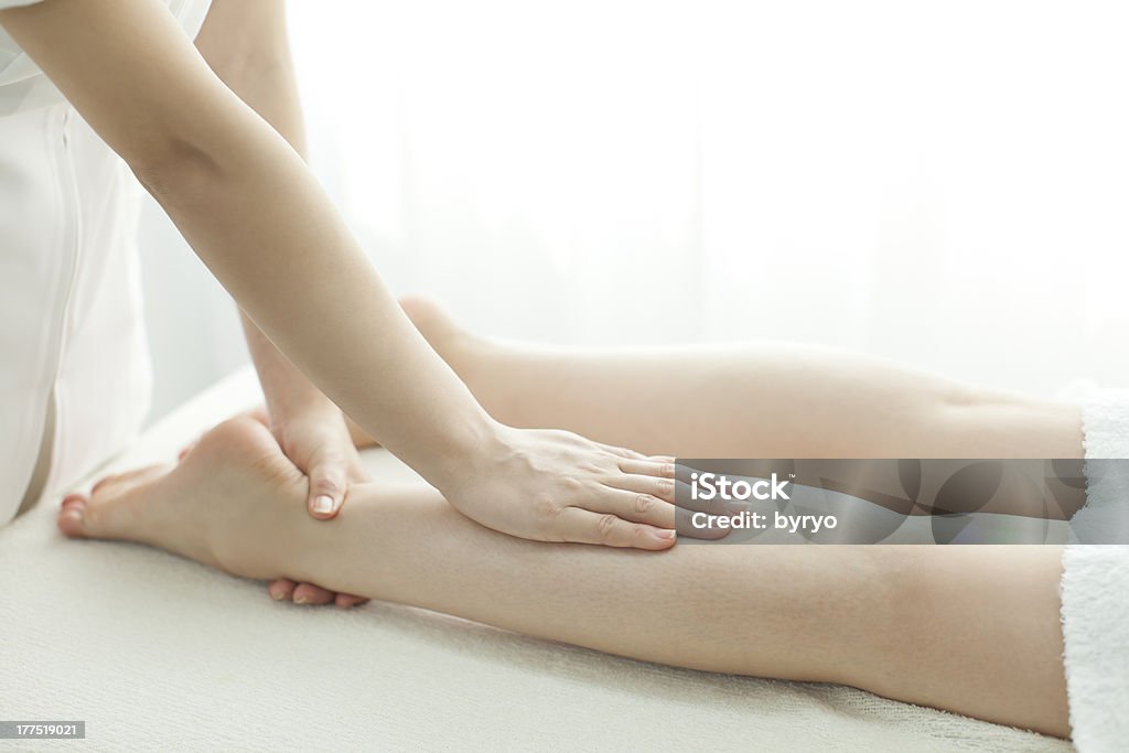 O esteticista que massagens de uma perna - Foto de stock de Adulto royalty-free