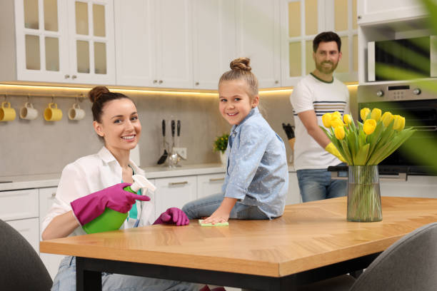 spring cleaning. parents with their daughter tidying up kitchen together - two parent family indoors home interior domestic kitchen imagens e fotografias de stock