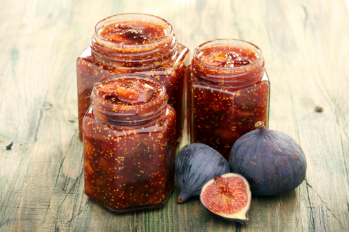 Fig jam in jars on a wooden table.