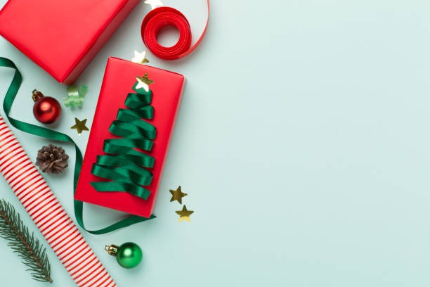 istock Gift boxes with paper's rools and christmas decoration on color background, top view 1775202333