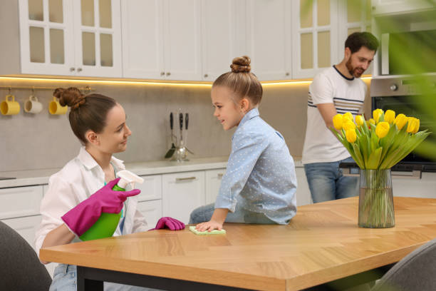 spring cleaning. parents with their daughter tidying up kitchen together - two parent family indoors home interior domestic kitchen imagens e fotografias de stock