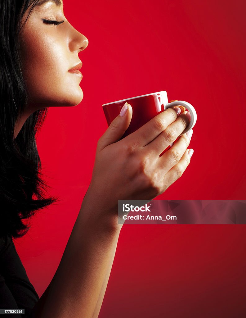 Beautiful lady drinking coffee Beautiful lady drinking coffee, brunette enjoy cup of hot chocolate, side view cute girl isolated on red background, portrait of female with morning tea, gorgeous woman holding cappuccino mug Coffee - Drink Stock Photo