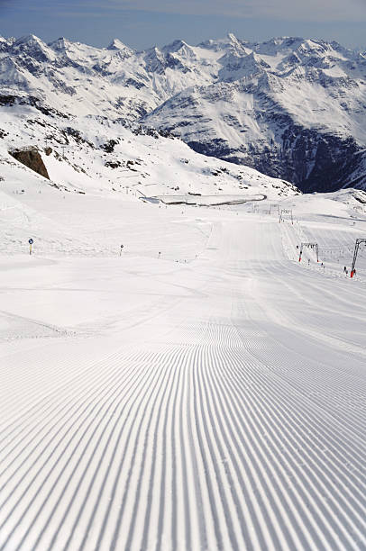 fresh ski track groomed ski track at Solden glacier and beautiful mountain range at background tiefenbach stock pictures, royalty-free photos & images