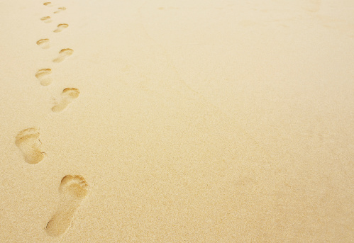 Bare footprint in the sand on beach on cloudy day in autumn. Portobello beach, Edinburgh, UK.