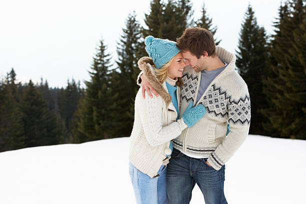 Young couple side hugging in alpine snow scene