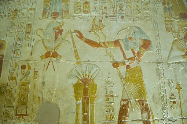 Thoth praising Osiris bas relief "Ancient Egyptian bas relief showing the Ibis headed god Thoth praising god of the dead Osiris.  Wall at Abydos Temple, el Balyana, Egypt.Ancient carving on public display over 2000 years." abydos stock pictures, royalty-free photos & images