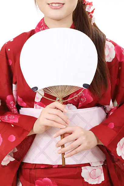 Young asian woman in traditional clothes of kimono with paperfan