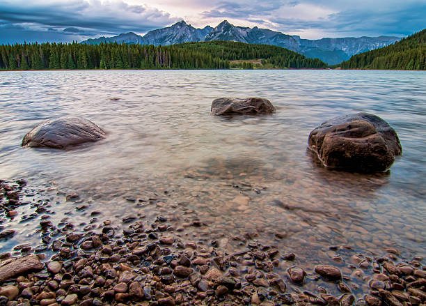 Mountain Peaks with Three Rocks in Lake stock photo