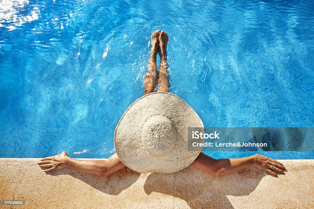 Woman at poolside Woman with hat at poolside Swimming Pool Stock Photo