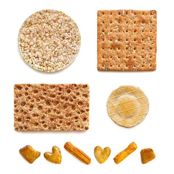 "Assorted crackers, isolated on white background.  Includes rice, wholegrain, rye, cheese cracker, and rice cracker party snacks."