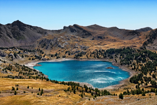 Image of Lac D'Allos (2228 m) during a windy day with sunlight relections on the rippled water surface. This lake  is the largest natural lake (54 ha)  in Europe at this altitude.It is located in The South Alps (Alpes de Haute Provence) in The Mercantour National Park in South-East of France.More images from