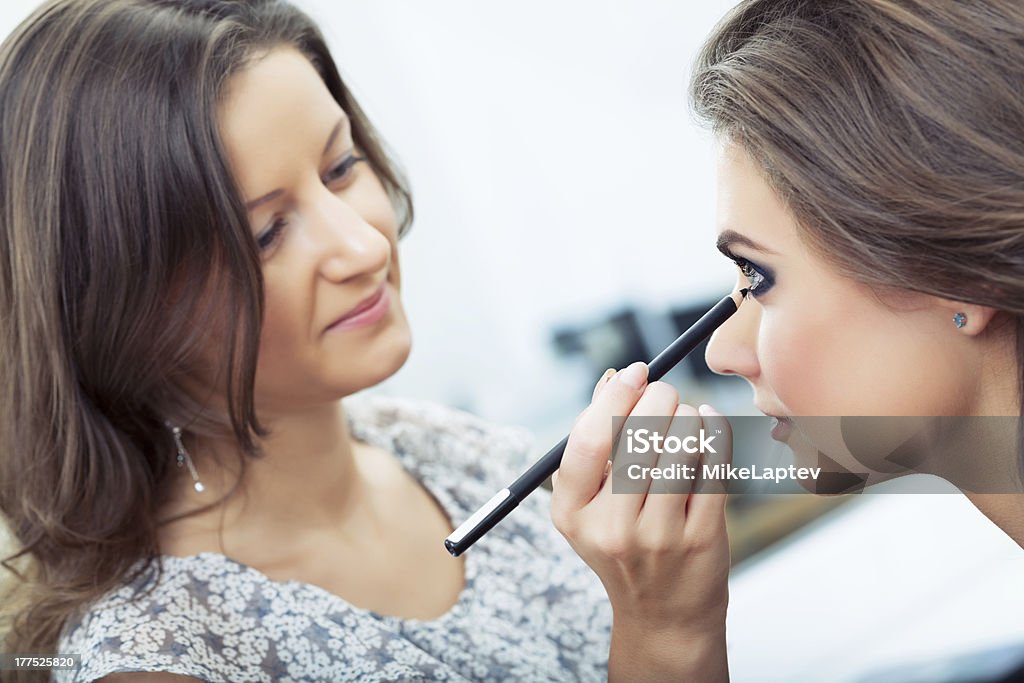 Applying kohl "Make-up artist applying eyeliner on model's lower lid, selective focus on model, close up" Adult Stock Photo