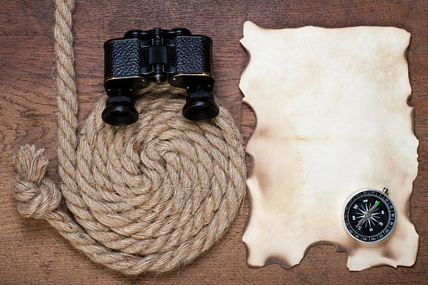 istock Burnt paper, compass, binoculars, rope on wood 177526039