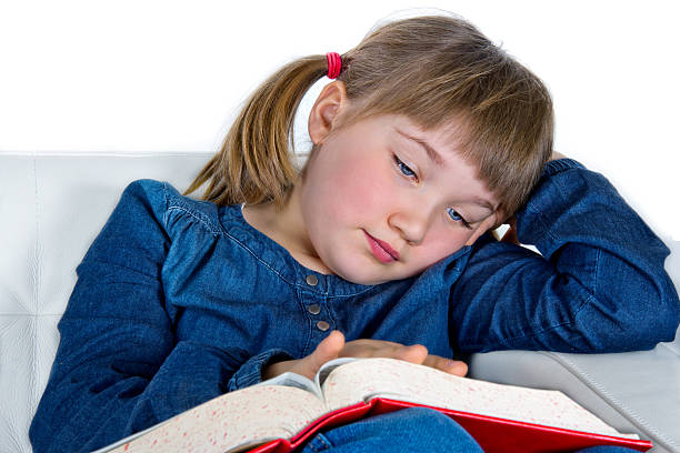 istock Cute girl reading book sitting on a couch 177526045