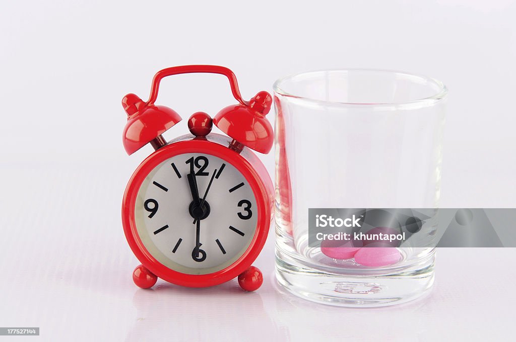 Vidrio de reloj y medicina rojo sobre fondo blanco - Foto de stock de Asistencia sanitaria y medicina libre de derechos