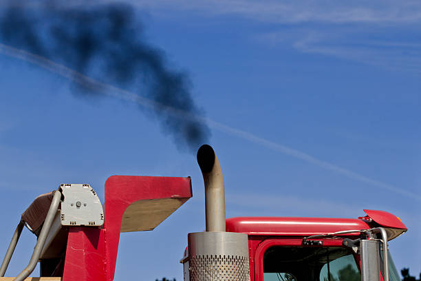 Color Image of Black Exhaust From a Red Truck "Image of red colored truck with very dark exhaust, possibly polluting the environment." vapor trail photos stock pictures, royalty-free photos & images