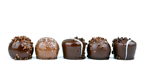 linea di tartufi al cioccolato su sfondo bianco - truffle chocolate candy chocolate candy foto e immagini stock