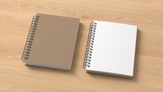 Notebook mockup. Closed and open blank notebook with craft paper cover. Spiral notepad on wooden background. 3d illustration