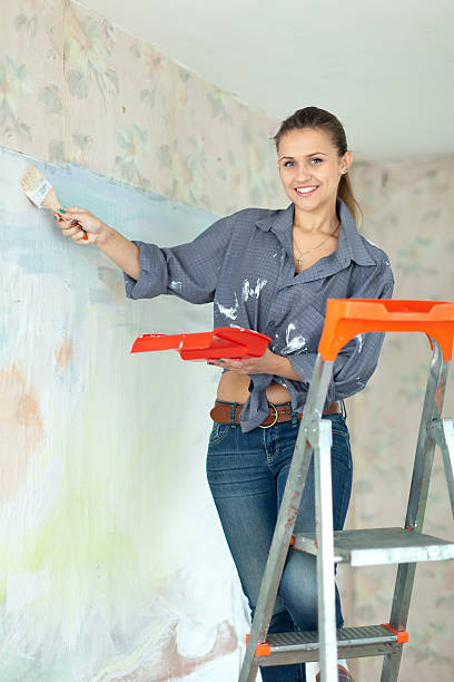 istock Happy girl paints wall with brush 177528235