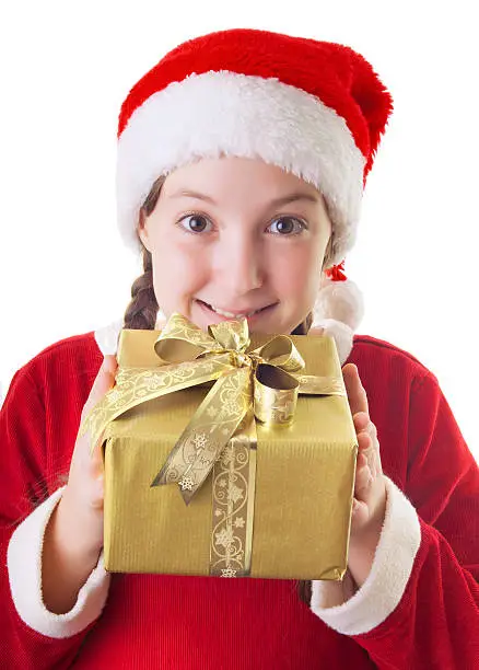 Beautiful girl dressed in Christmas clothes and red santa hat with present in her hands isolated on white background