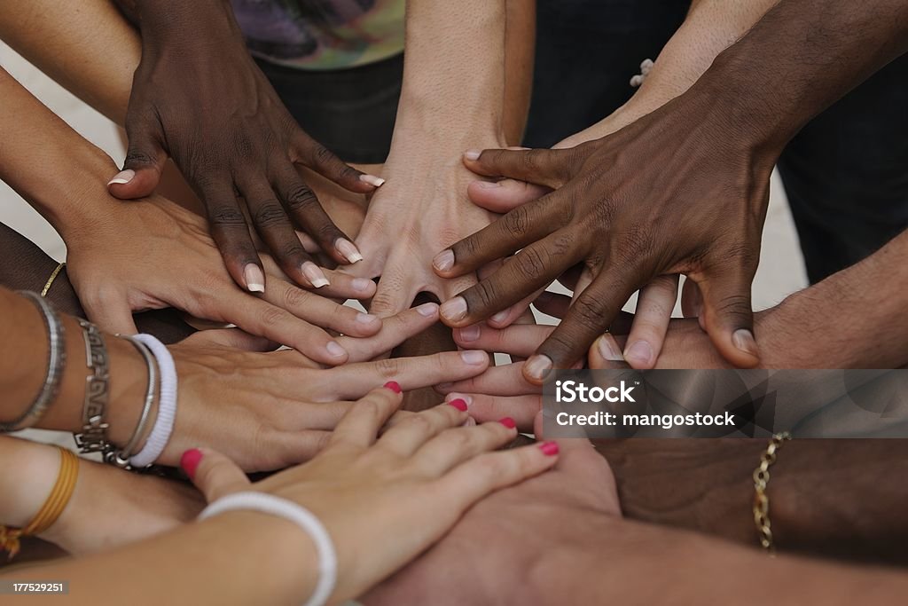 Diverse human hands showing unity Multiracial Group Stock Photo