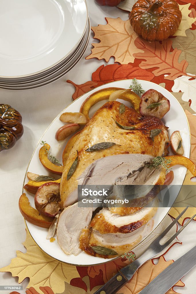 Turkey Breast With Sage - Honey Rub Sage - honey butter rub turkey breast garnished with roasted pumpkin and apples in fall themed surrounding. Roast Turkey Stock Photo