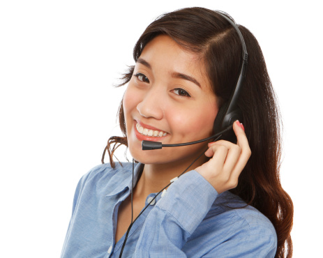 A young smiling woman wearing a headset (isolated on white)
