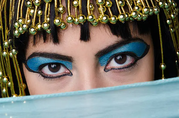 Close-up on Cleopatra make-up eyes mysteriously looking at viewer.