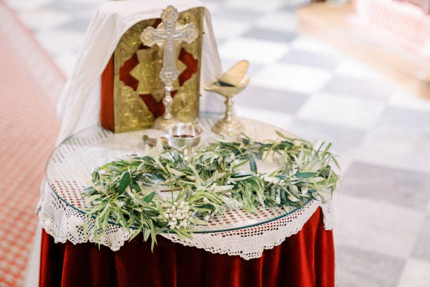 coroas verdes jazem sobre a mesa ao lado de taças de prata, uma cruz e uma bíblia na igreja - 13601 - fotografias e filmes do acervo