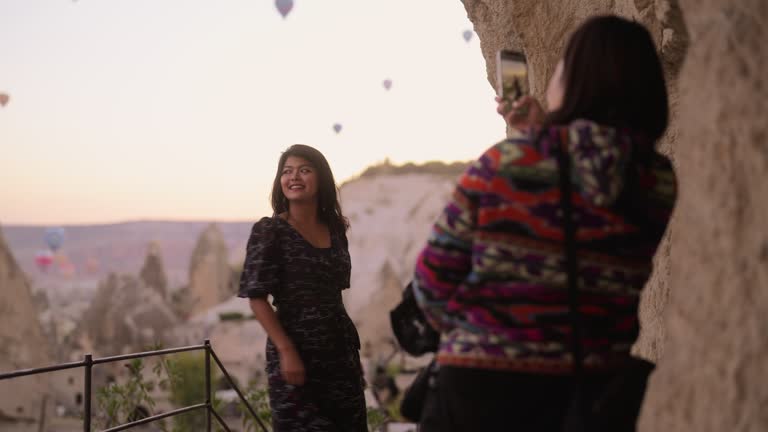 Two multi-racial female friends taking photos in Cappadocia