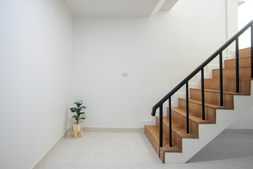 Wood staircase inside contemporary white modern house interior.